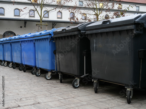 Eine Reihe von Müllcontainern für Papiermüll und Restmüll in einem Hof