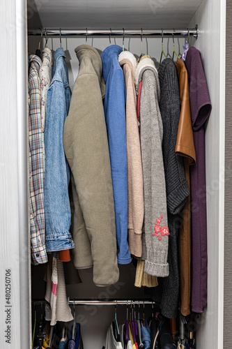 various clothes hanging on a hanger in a wardrobe