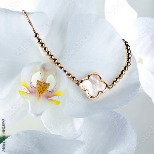 Golden necklace with pendant on orchid flower
