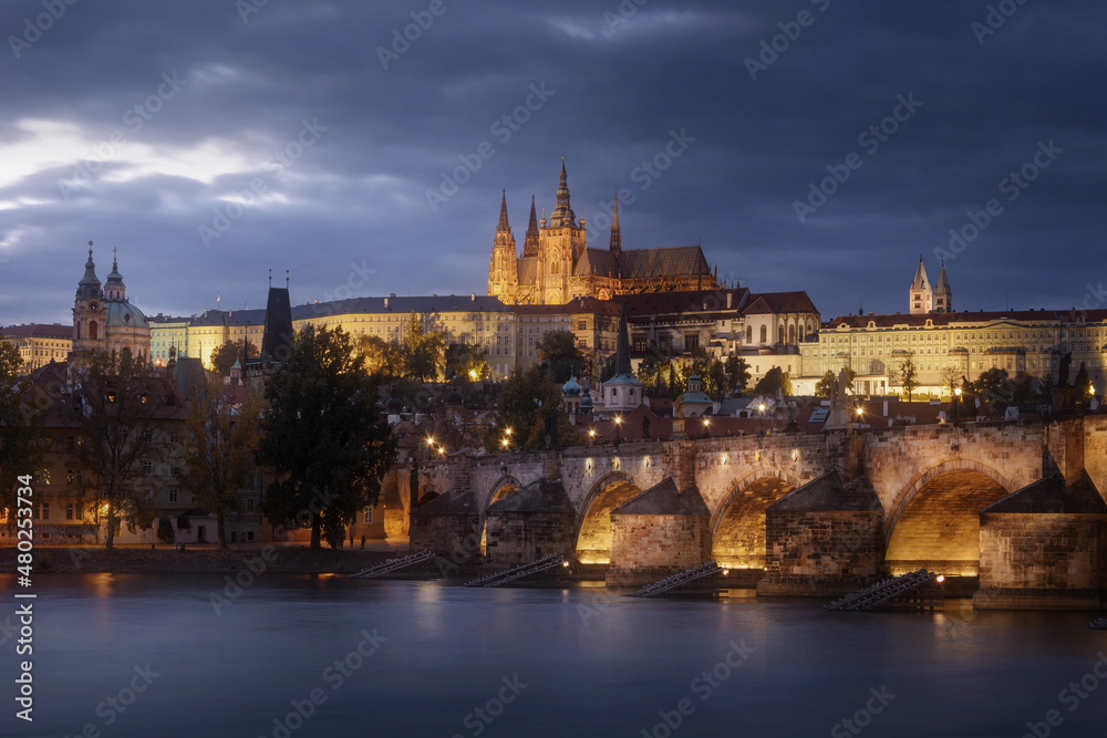 Prague Castle and Charles bridge with dramatic clouds at night, Czech Republic