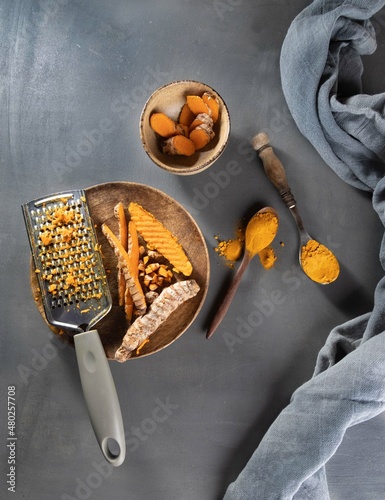 Healthy spices curcuma poweder and roots on grey background .Copy space photo