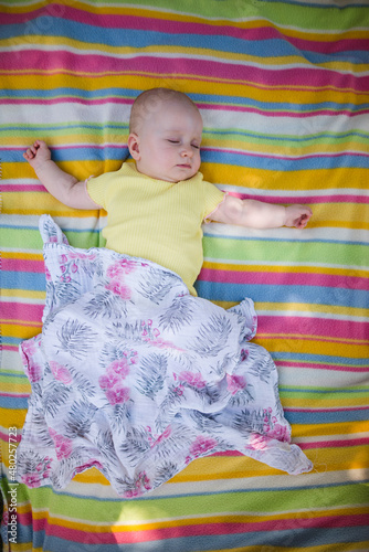 a little baby sleeping outside on a blanket