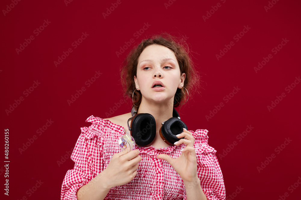 Obraz premium woman wearing headphones glasses with diamond fashion posing red background