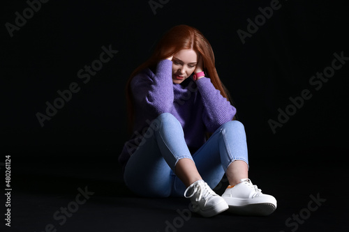 Scared young woman on dark ...