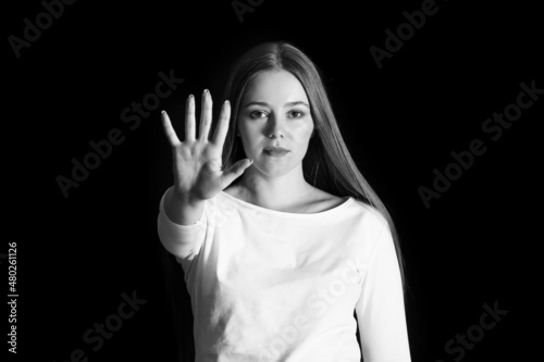 Young woman showing STOP ge...