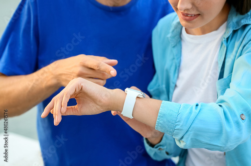 Couple of young tourists with smartwatch outdoors, closeup