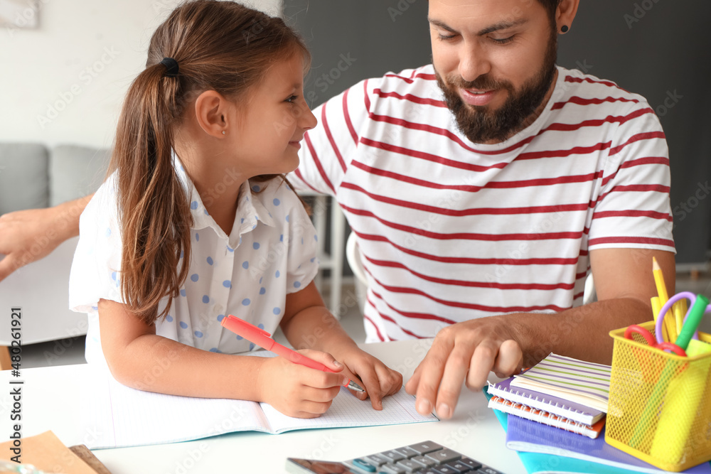 Man helping his little daughter to do lessons at home Man helping his little daughter to do lessons at home