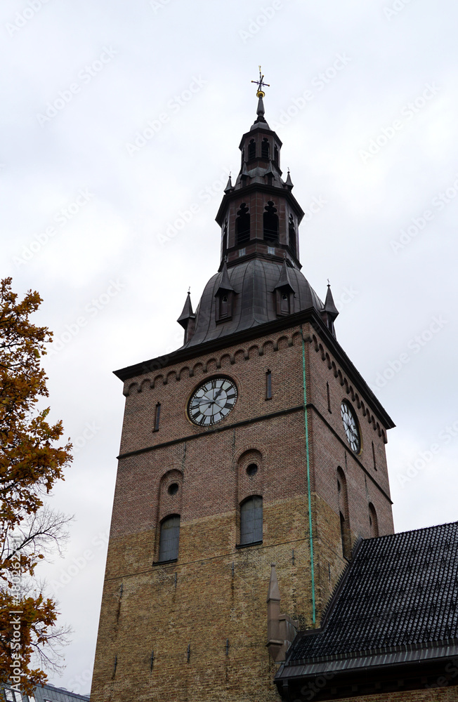 A church tower with a clock showing the exact time on a cloudy day
