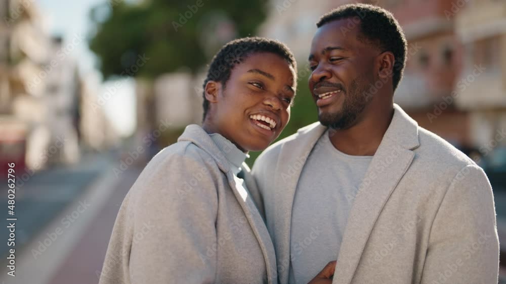 African american couple smiling confident hugging each other and speaking at street African american couple smiling confident hugging each other and speaking at street
