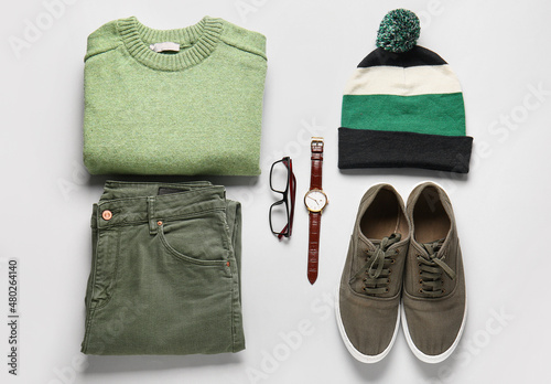 Male sweater, pants, hat, shoes and accessories on light background