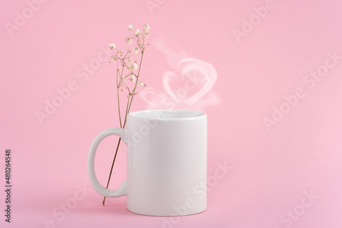 Mockup white coffe cup or mug on a pink background. Hot drink steam in the form of heart