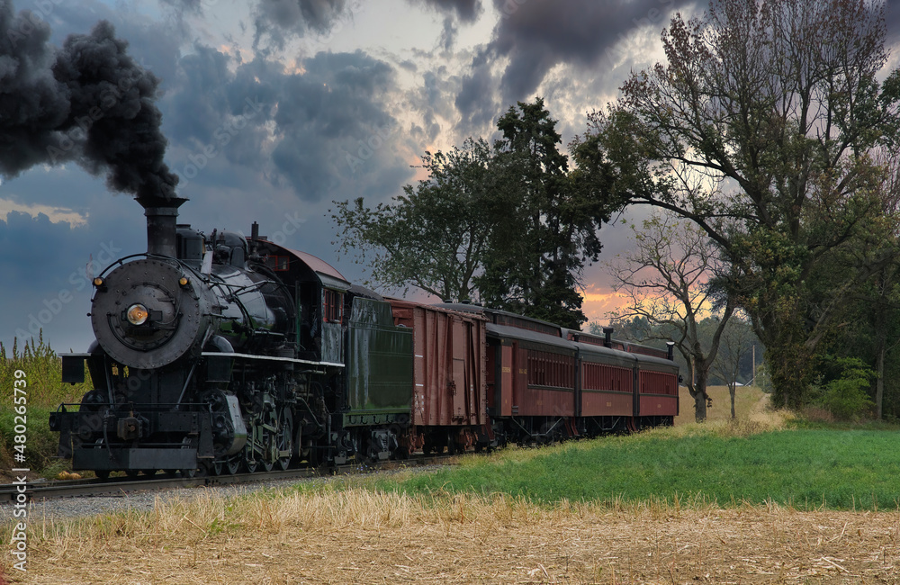 Fototapeta premium An Antique Restored Steam Freight Train Approaching Head on Blowing Smoke and Steam