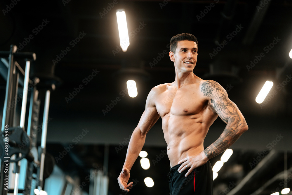 Fitness trainer posing with muscular back posture at gym. Fitness healthy life concept Fitness trainer posing with muscular back posture at gym. Fitness healthy life concept