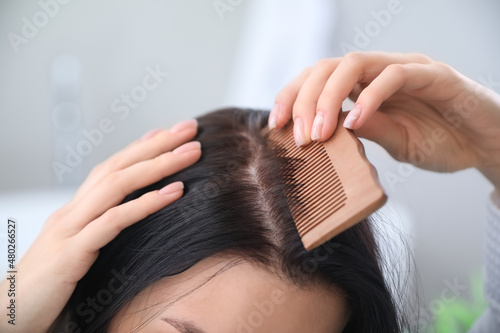 Morning of young woman combing hair at home