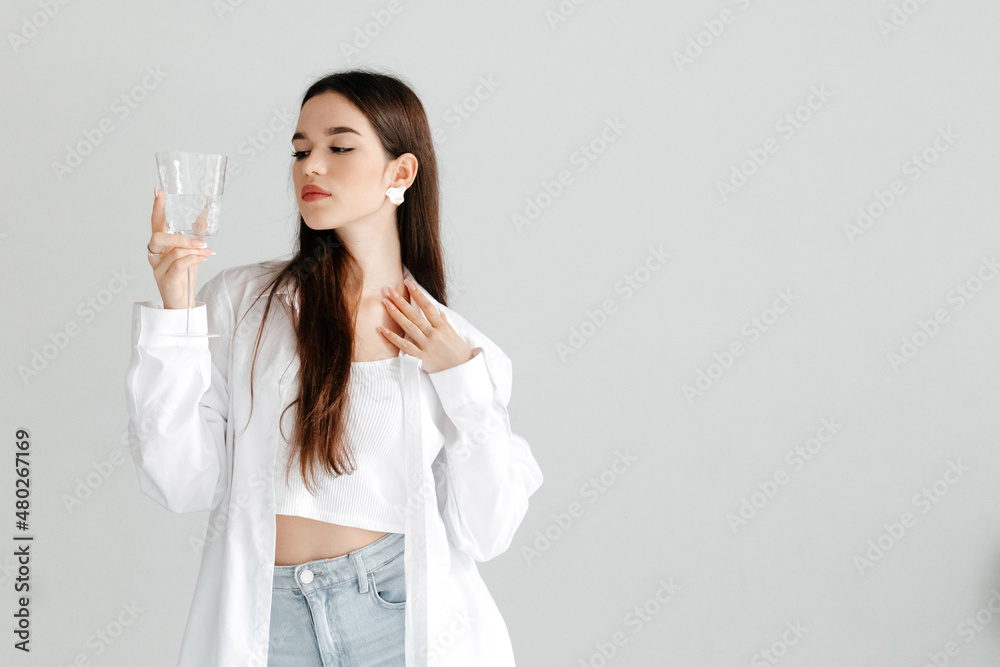 Young smiling woman holding glass of water, studio portrait on white. Young smiling woman holding glass of water, studio portrait on white.