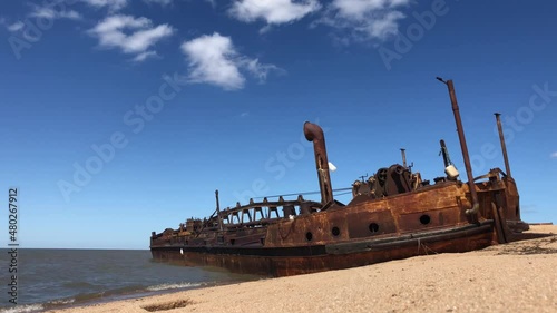 Shipwreck of an abandoned sand boat on Juan Lacaze beach in UruguayWreck of an abandoned sand boat on Juan Lacaze beach in Uruguay. Details of the deep blue sky with some cloud can be seen in the back photo