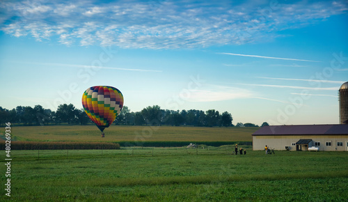 Hot Air Balloons Landing in Farmlands as Amish Look on, and More Still in Flight © Greg Kelton