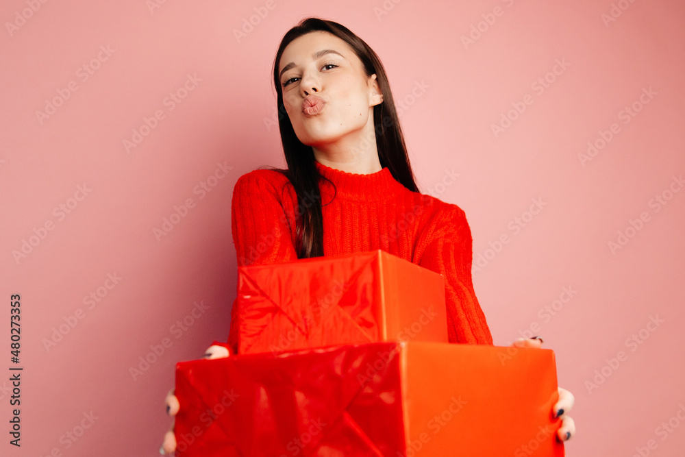 Young attractive woman shows happiness. The girl is standing with gifts in her hands. Concept of the St. Valentine's Day Young attractive woman shows happiness. The girl is standing with gifts in her hands. Concept of the St. Valentine's Day