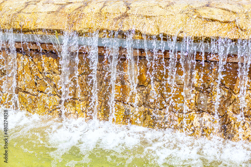Artificial waterfall . Flowing water of fountain 