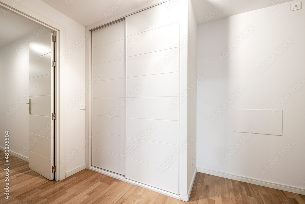 White sliding door wardrobe with oak parquet flooring White sliding door wardrobe with oak parquet flooring