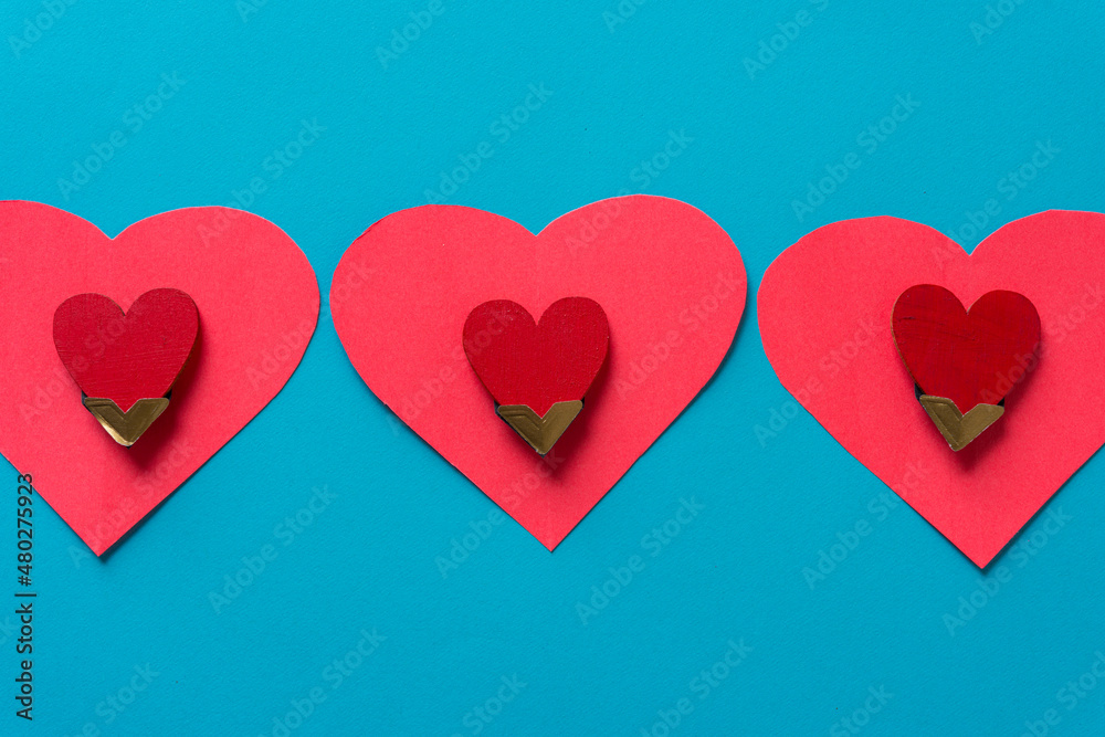 wooden hearts in photo corners on hot pink hearts on blue paper