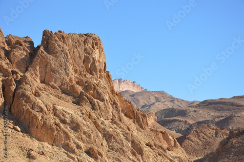 Atlas mountains near the Chebika oasis in west Tunisia, Africa. Whie, yellow, orange and brown rocks and blue sky.