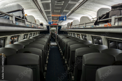 Boston, USA - October 22, 2021: Empty interior of Amtrak train with rows of seats. Inside of a dark train during pandemic