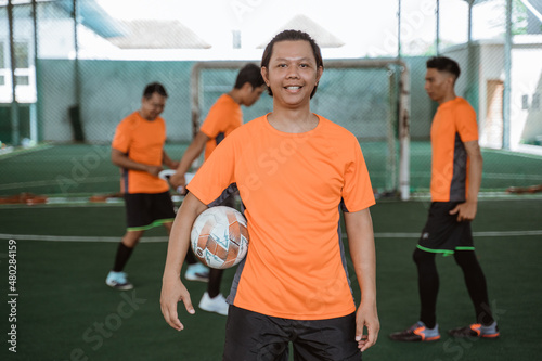 male futsal player smiling while carrying the ball © Odua Images