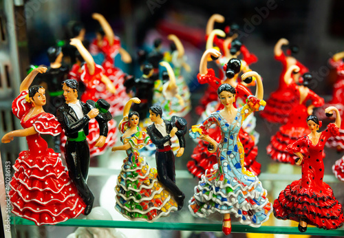 Variety of handcrafted ceramic figurines of Spanish flamenco dancers on shelves of souvenir shop