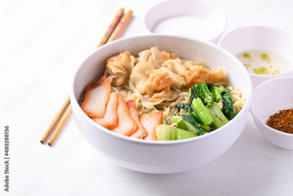 Noodles soup with wonton dumpling and grilled red pork in bowl on white background, Asian food Noodles soup with wonton dumpling and grilled red pork in bowl on white background, Asian food