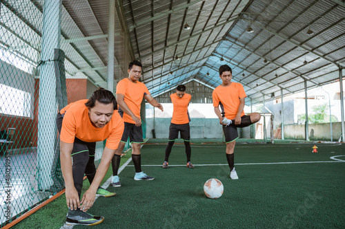 futsal players stretch with the team before the futsal match photo