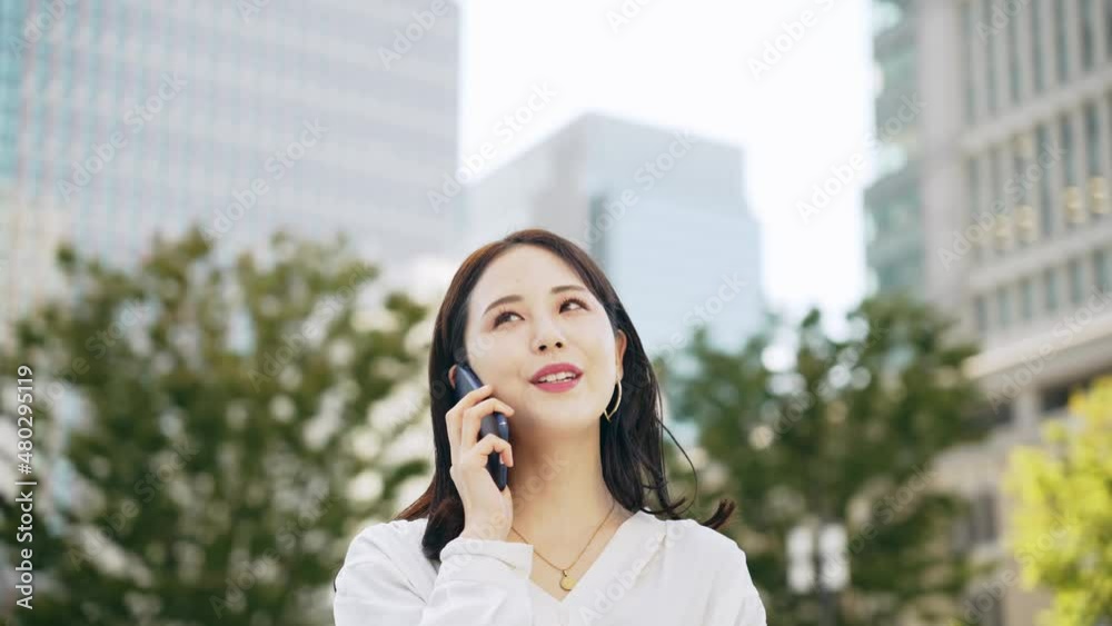 屋外でスマホを使って通話する女性