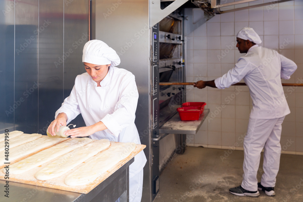 Female baker prepares delicious dough coca bread at bakery