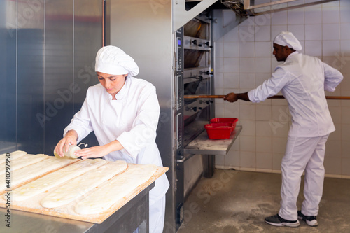 Female baker prepares delicious dough coca bread at bakery