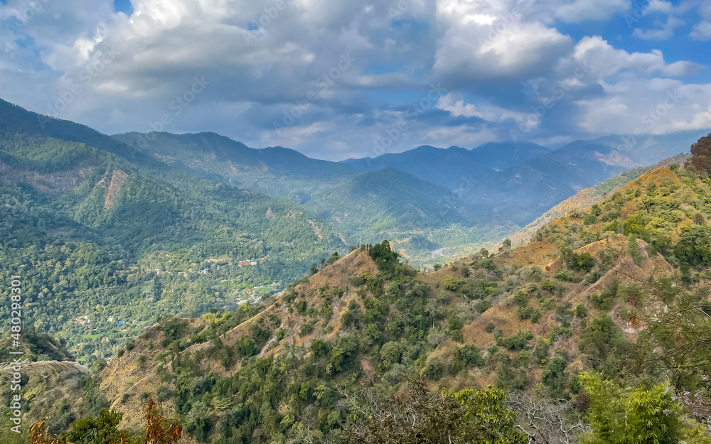 A mountain valley with green vegetation on it and hills all around it