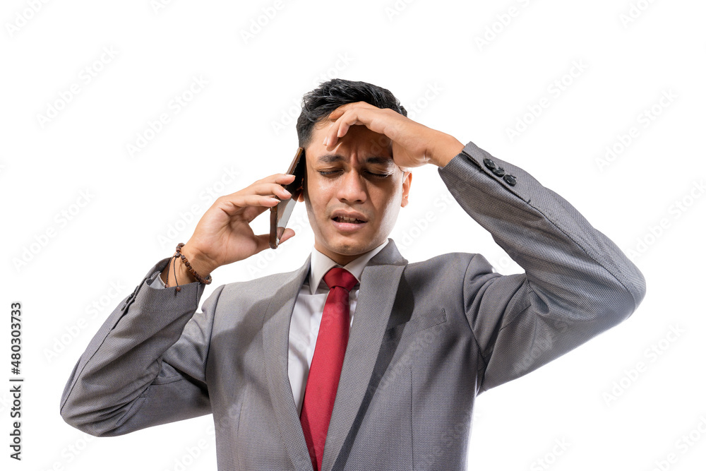 stressed young man wearing suit hold his head while making a phone stressed young man wearing suit hold his head while making a phone
