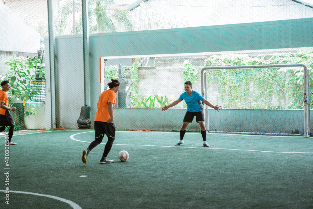 Fototapeta premium a player dribbles against the goalkeeper while playing futsal