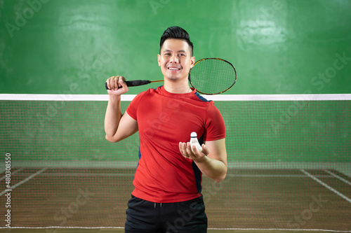 Handsome badminton player standing holding racket and shuttlecock © Odua Images