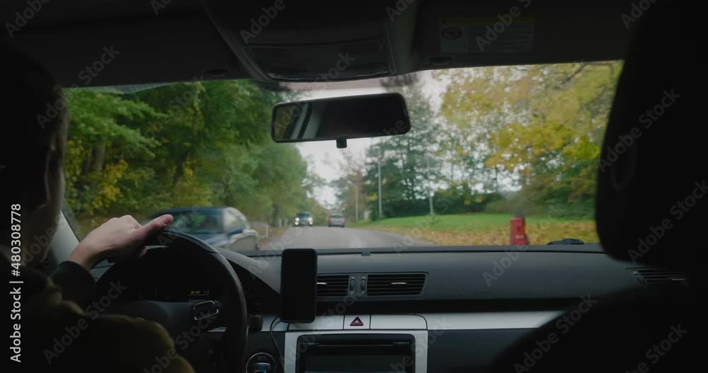 Young Man Drives On a Small Bumpy Road With Yellow and Green Trees Around in Fall, Simrishamn Sweden - Handheld Medium OTS Shot Young Man Drives On a Small Bumpy Road With Yellow and Green Trees Around in Fall, Simrishamn Sweden - Handheld Medium OTS Shot