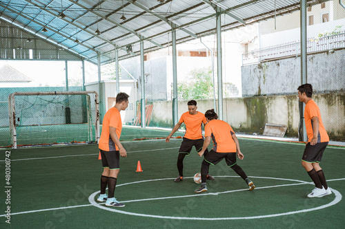 futsal player tries to prevent another player from passing