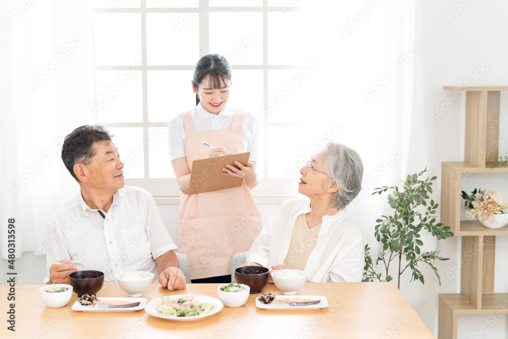 高齢者の食事をチェックする女性（栄養士）
