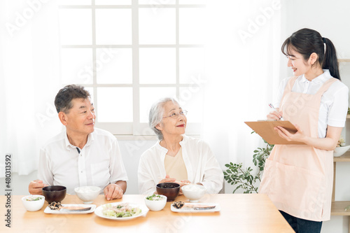 高齢者の食事をチェックする女性（栄養士）
