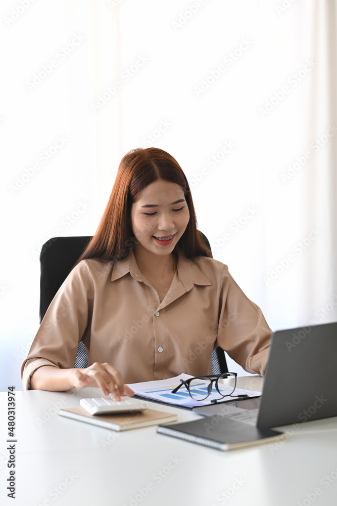 Portrait of smiling businesswoman sitting in modern workplace an working with laptop. Portrait of smiling businesswoman sitting in modern workplace an working with laptop.