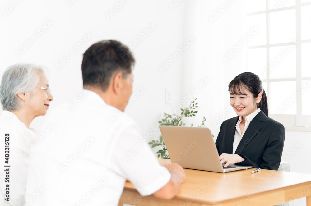 パソコンで説明するスーツ姿の女性と高齢者夫婦
パソコンで説明するスーツ姿の女性と高齢者夫婦