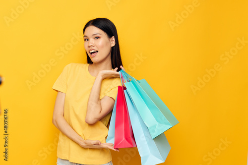 woman with Asian appearance woman with packages in hands shopping isolated background unaltered