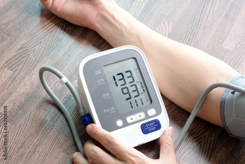 Man check blood pressure monitor and heart rate monitor with digital pressure gauge. Health care and Medical concept Man check blood pressure monitor and heart rate monitor with digital pressure gauge. Health care and Medical concept