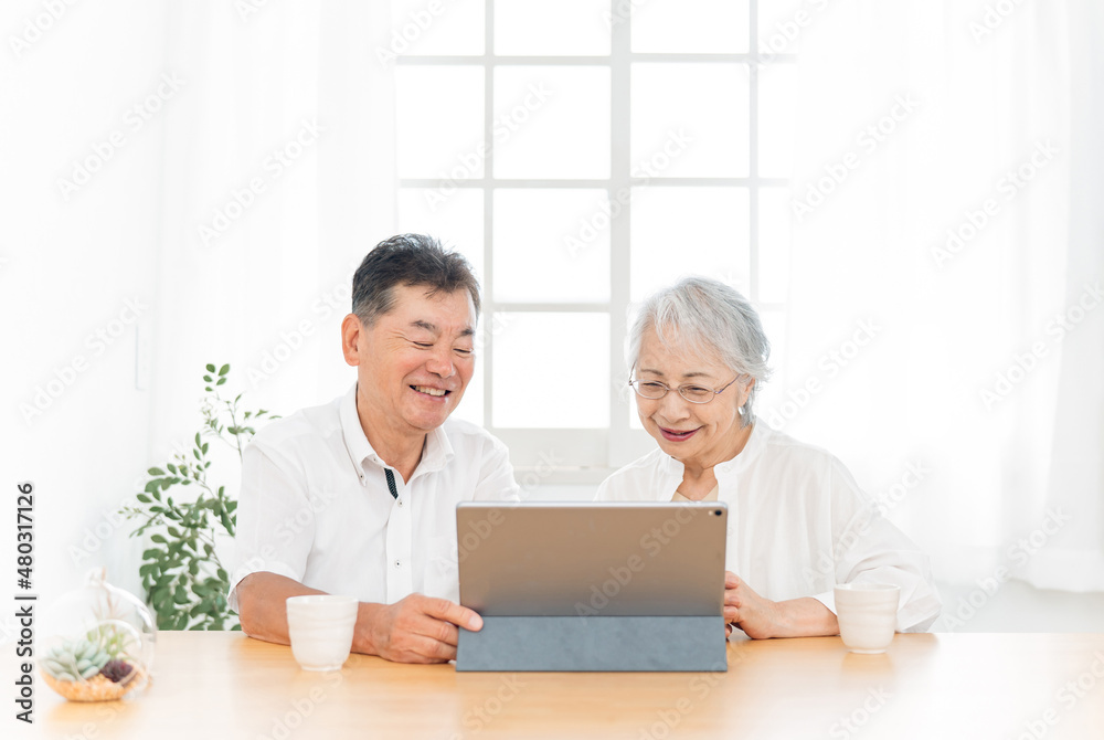 タブレットPCを見る高齢者夫婦(笑顔)
タブレットPCを見る高齢者夫婦(笑顔)