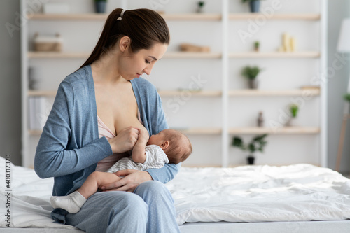 Lactation Concept. Beautiful Smiling Woman Feeding Newborn Baby With Breast At Home photo