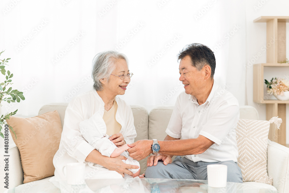 Obraz premium 孫を抱く高齢者女性と男性 