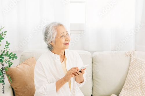 スマホを使う高齢者女性（笑顔）  © buritora